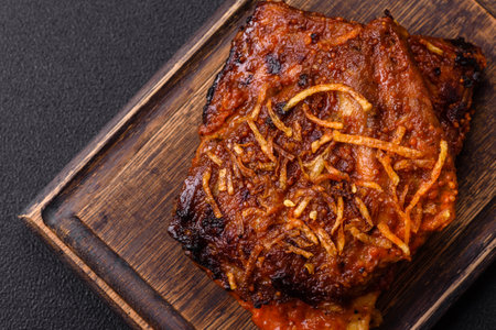 Delicious pork or beef ribs baked on the grill with salt, spices and herbs on a dark concrete...