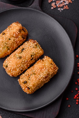 Delicious hearty vegetarian or vegan dish in the form of cutlets or patties consisting of potatoes, carrots, onions and beans on a dark concrete backgroundの写真素材