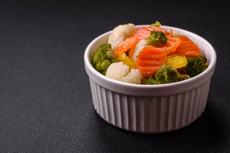 Delicious fresh vegetables broccoli, cauliflower, carrots steamed with salt, spices and herbs on a plain backgroundの写真素材