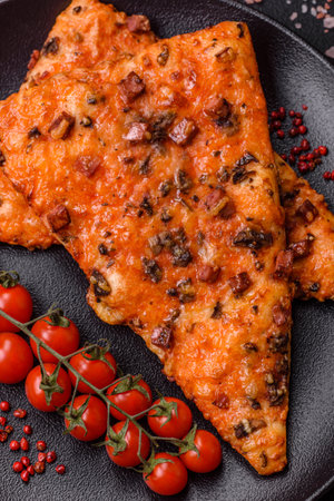 Slices of delicious street pizza with sausage, mushrooms, tomatoes and cheese with salt and spices on a dark concrete backgroundの写真素材