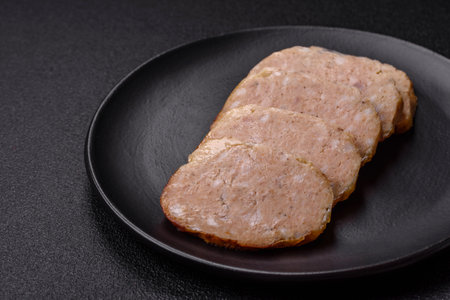 Delicious roll or homemade minced chicken sausage with salt, spices and herbs on a dark concrete backgroundの写真素材