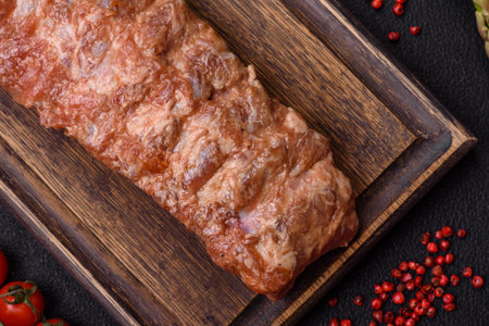 Raw pork ribs marinated with salt, spices and herbs on a dark concrete backgroundの写真素材