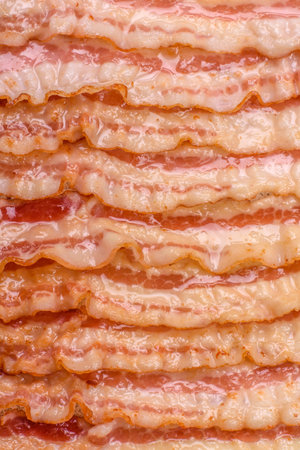 Delicious bacon in the form of slices with salt, spices and herbs on a dark concrete backgroundの写真素材