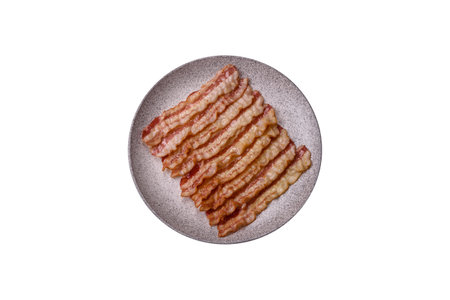 Delicious bacon in the form of slices with salt, spices and herbs on a dark concrete backgroundの写真素材