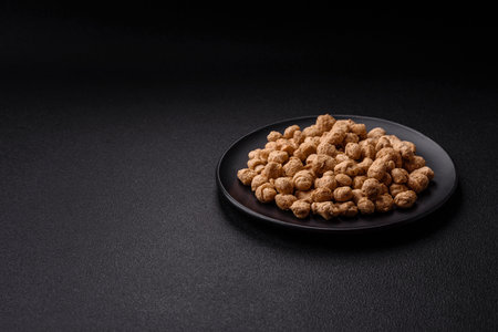 Dry soybean meat pellets, diet food for vegan and vegetarian cuisine on dark concrete background