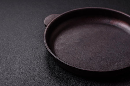 Empty ceramic round plate on dark textured concrete background. Cutlery, preparation for dinnerの写真素材