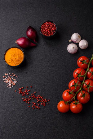 Ingredients for cooking at home pepper, salt, spices and herbs on a dark concrete backgroundの写真素材