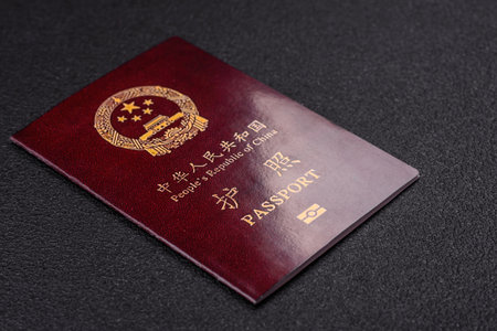 Physical paper international passport of a Chinese citizen on a dark concrete background