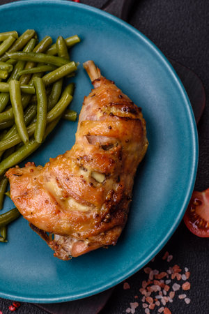 Delicious grilled chicken leg or quarter with salt and spices on dark concrete background
