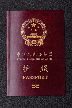 Physical paper international passport of a Chinese citizen on a dark concrete backgroundの写真素材