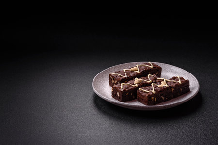 Delicious sweet brownies with chocolate and nuts on a dark concrete backgroundの写真素材