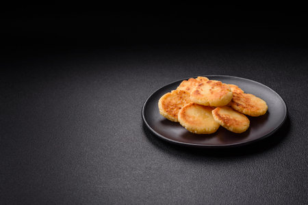 Delicious fresh sweet cheese pancakes with raisins and cinnamon on a ceramic plate