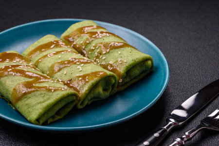 Spinach Crepes stuffed with chicken, mushrooms, salt and spices on a dark concrete background