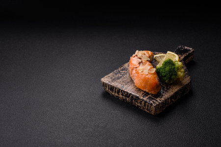 A piece of salmon with broccoli, salt and spices on a dark backgroundの写真素材