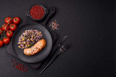 A piece of salmon with rice, broccoli, salt and spices on a dark concrete backgroundの写真素材