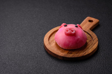 Delicious Japanese mochi dessert with colorful rice dough shell and fruit filling on dark concrete backgroundの写真素材