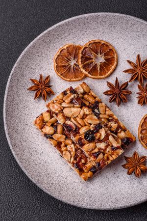 Delicious sweet nutrition bars with nuts, dried berries gluten free on dark concrete background