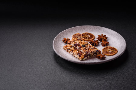 Delicious sweet nutrition bars with nuts, dried berries on dark concrete backgroundの写真素材