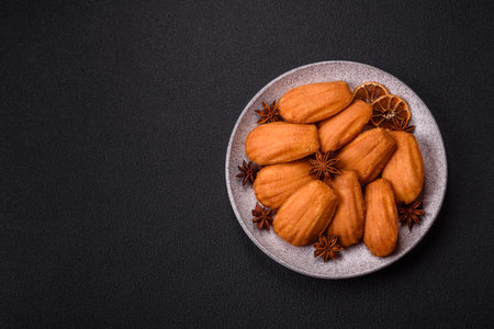 Traditional French madeleine biscuits with nutty flavor on a dark concrete backgroundの写真素材