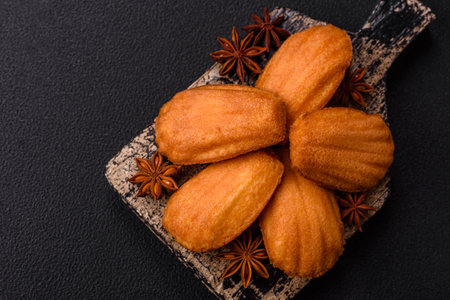 Traditional French madeleine biscuits with nutty flavor on a dark concrete backgroundの写真素材