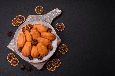 Traditional French madeleine biscuits with nutty flavor on a dark concrete backgroundの写真素材