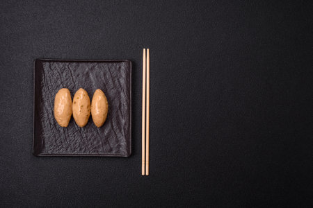 Fish or meat quenelles with delicate mushroom sauce, salt and spices on a dark concrete backgroundの写真素材