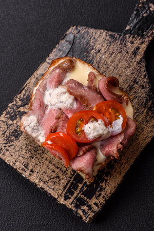 Sandwich with roast beef, tomatoes, stracciatello and vitello tonato sauceの写真素材