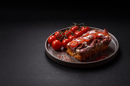 Sandwich with brioche bun, roast beef, tomatoes, stracciatello and vitello tonato sauceの写真素材