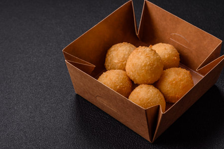 Fast food cheese balls breaded with salt and spices on a dark concrete backgroundの写真素材