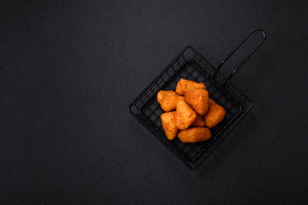 Breaded camembert or brie cheese baked in the form of nuggets with salt and spices on a dark concrete backgroundの写真素材
