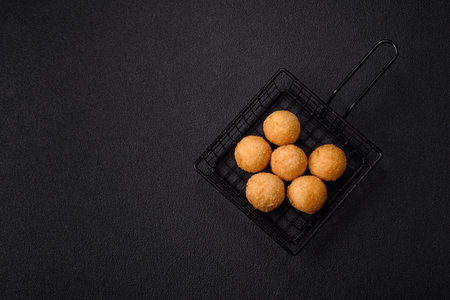 Fast food cheese balls breaded with salt and spices on a dark concrete backgroundの写真素材