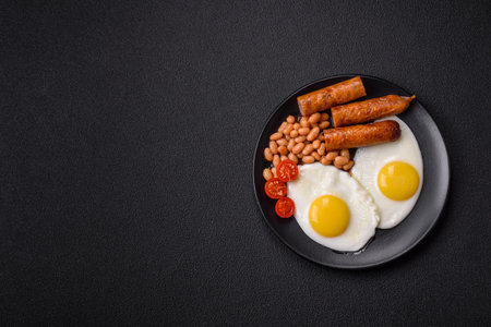 Full English breakfast with boiled eggs, beans, sausages, tomatoes, salt and spices on dark concrete...
