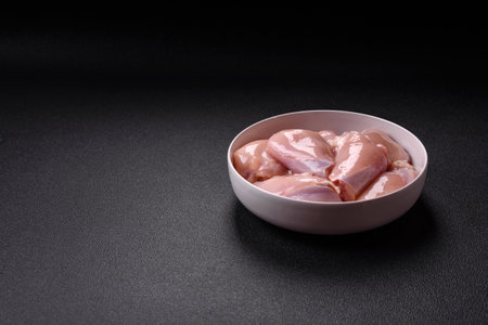 Fresh chicken fillet on a dark concrete table. Preparation for cooking meat dishesの写真素材