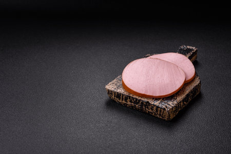 Delicious fresh ham with salt, spices and herbs on a dark concrete backgroundの写真素材