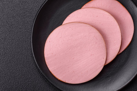 Delicious fresh ham with salt, spices and herbs on a dark concrete backgroundの写真素材