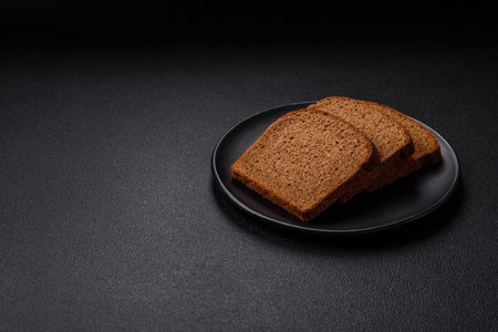 Fresh crispy brown bread sliced from whole grain flour with salt and spicesの写真素材