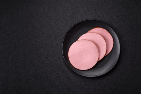 Delicious fresh ham with salt, spices and herbs on a dark concrete backgroundの写真素材