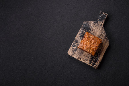 Chocolate sweet brownie cake in a square shape on a dark texture backgroundの写真素材