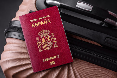 International passport of a citizen of Spain on a suitcase, departure from the airport, international travelの写真素材