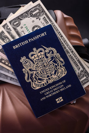 International passport of a citizen of Great Britain and Northern Ireland on a suitcase, departure from the airport, international travelの写真素材