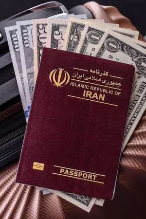 International passport of a citizen of Iran on a suitcase, departure from the airport, international travelの写真素材