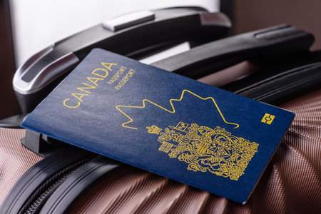International passport of a citizen of Canada on a suitcase, departure from the airport, international travelの写真素材