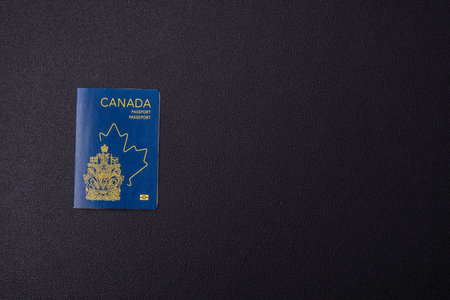 International passport of a citizen of Canada on a dark concrete background, international travel