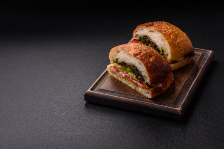 Ciabata with jamon or prosciutto, tomatoes, cheese and lettuce with salt, spices and herbsの写真素材