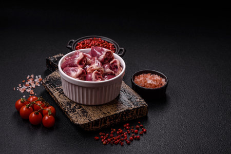 Raw chicken hearts with salt, spices and herbs on a dark concrete backgroundの写真素材
