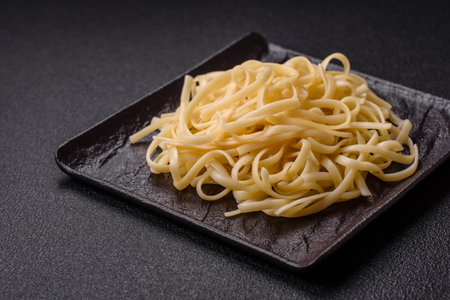 Rice noodles with beans, meat, tomato sauce, spices and herbs on a dark concrete backgroundの写真素材
