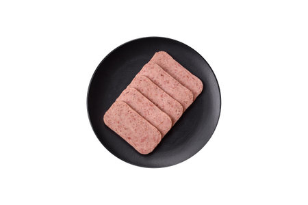 Delicious canned pink spiced ham with salt, spices and herbs on a white backgroundの写真素材