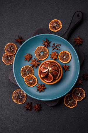 Sweet tart with figs, cheese cream and pecans on a dark concrete backgroundの写真素材