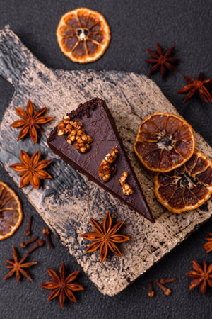 Piece of sweet chocolate cake with nuts on dark concrete backgroundの写真素材