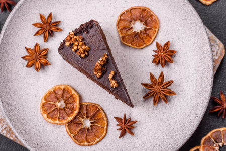 Piece of sweet chocolate cake with nuts on dark concrete backgroundの写真素材